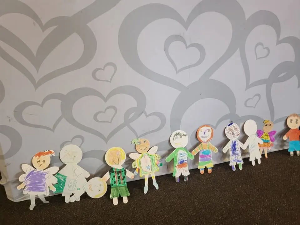 A row of paper figures the children coloured in during a craft activity at a family party